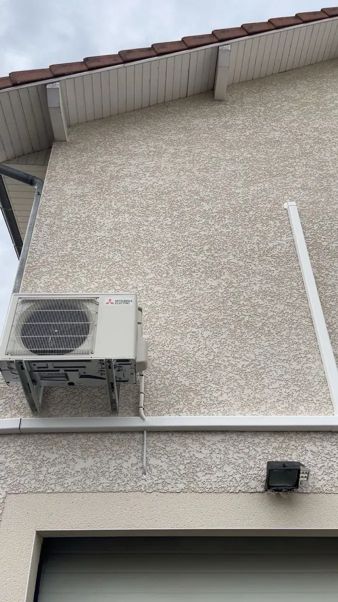 Unité extérieure de climatisation intégrée à la façade d’une maison