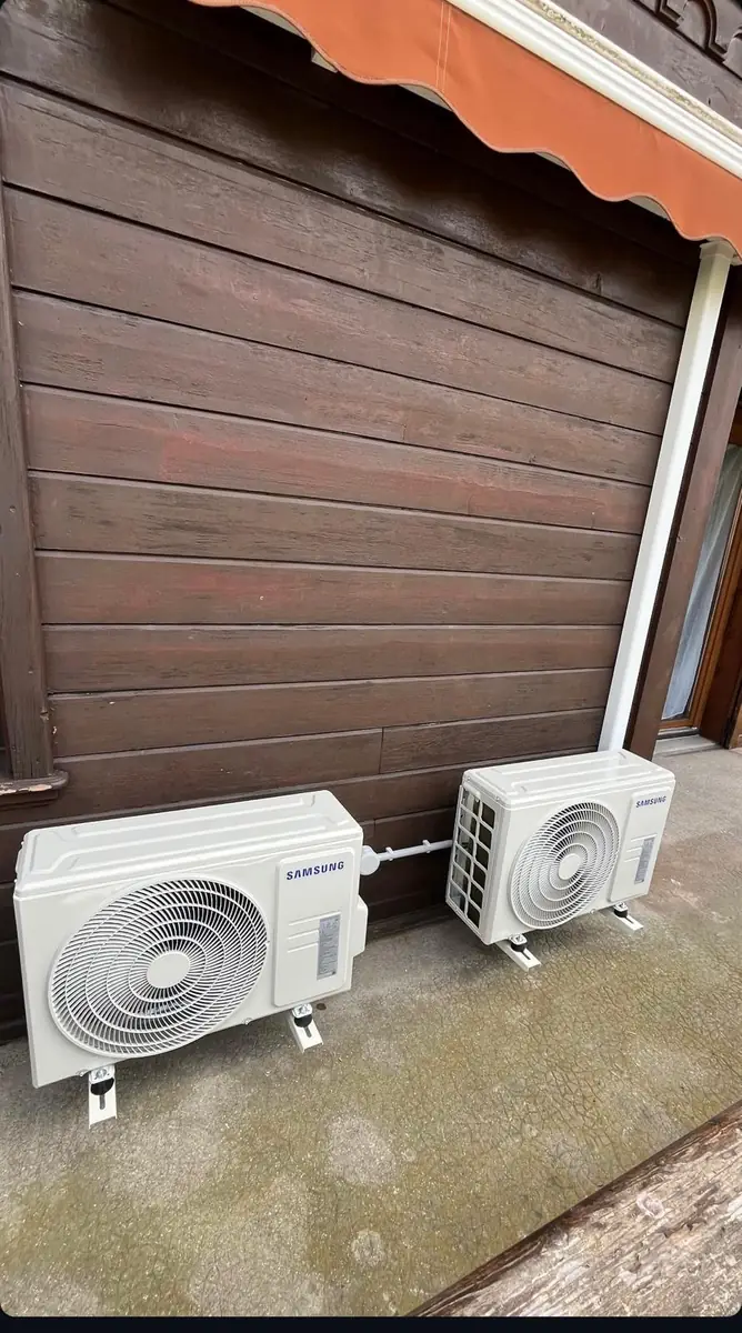 Deux unités extérieures Samsung posées sur une terrasse avec bardage bois